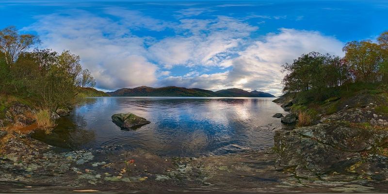 Loch Lomond at sunset with hills reflected in still water