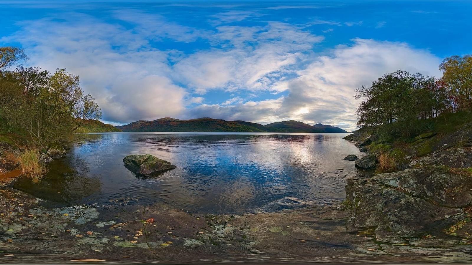 Loch Lomond at sunset with hills reflected in still water