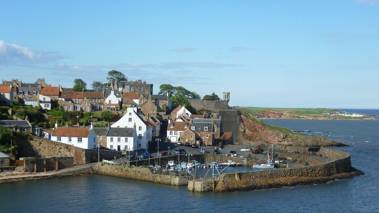 Crail harbour in the East Neuk of Fife, its stone pier and painted cottages above the water